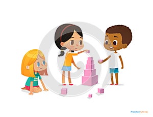 Multiracial children build tower with pink blocks. Kids play using kit