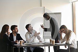 Multiracial colleagues argue at company meeting in office photo