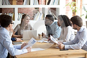 Multiracial colleagues brainstorm during company meeting in offi