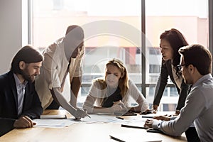 Multiracial colleagues discuss financial paperwork at meeting