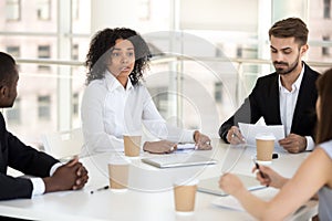 Multiracial colleagues negotiate during briefing in office