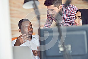 Multiracial contemporary business people working connected with technological devices like tablet and laptop