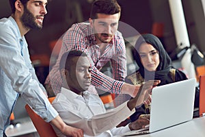 Multiracial contemporary business people working connected with technological devices like tablet and laptop