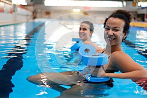 Multiracial couple attending water aerobics class in a swimming pool