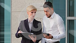 Multiracial couple of business colleagues arabic hispanic man and mature caucasian woman with short hair standing