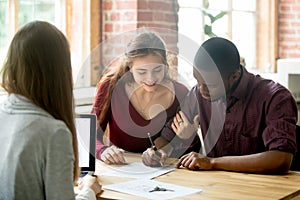 Multiracial couple signing deal from real estate agent