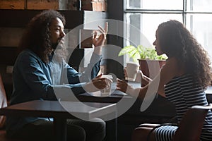 Multiracial couple talk on date in cozy coffeehouse photo