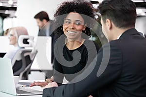 Multiracial coworkers discussing work moments seated in co-working space