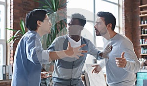 Multiracial coworkers having quarrel in office, conflict of interest