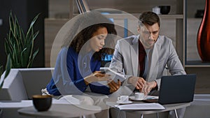 Multiracial coworkers team discuss marketing project using laptop in cafe office