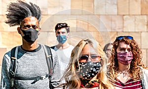 Multiracial crowd walking near wall at city urban context - New normal lifestyle concept with young people covered by mask photo