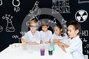 Multiracial diverse kids with test tubes studying chemistry at school laboratory