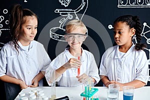 Multiracial diverse kids with test tubes studying chemistry at school laboratory