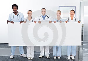 Multiracial doctors holding placard