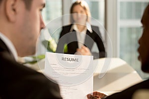 Multiracial employers making hiring decision, focus on resume, j