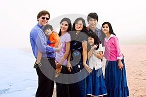 Multiracial family of seven on foggy beach