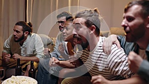 Multiracial football fans watching soccer match on TV and celebrating victory