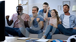 Multiracial friends celebrating goal, watching football at home, togetherness