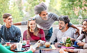 Multiracial friends drinking coffee at bar outdoors - People talking and having genuine fun together at cafeteria garden