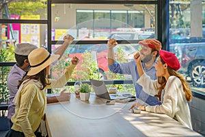 Multiracial friends or group of tourist having arms raise together during sitting in coffee shop