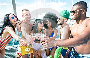 Multiracial friends having fun drinking champagne wine at sail boat party - Friendship concept with young multi racial people