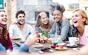 Multiracial friends having fun drinking together at coffee house - Young people laughing at restaurant cafeteria