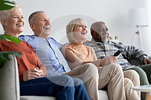 Multiracial friends senior people watching TV and laughing