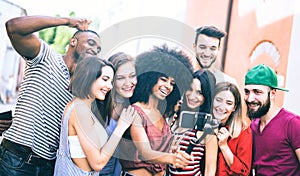 Multiracial friends taking video selfie with mobile phone on stabilized gimbal - Young people having fun on new tech trends photo
