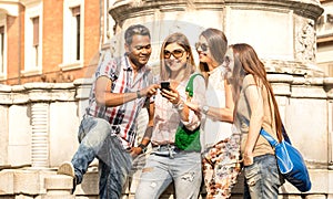 Multiracial friends using mobile smart phone at city tour - Happy friendship concept with student having fun together - Millenial