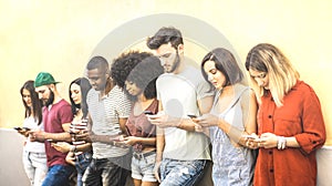 Multiracial friends using mobile smartphone at university coampus - Millenial people addicted by smart phones - Tech concept photo