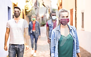 Multiracial friends walking with face mask after lockdown reopening - New normal friendship concept with guys and girls