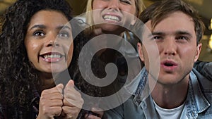 Multiracial friends watching match in pub, disappointed about referee decision