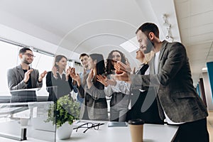 Multiracial group of business people clapping hands to congratulate their boss - Business company team, standing ovation after a photo