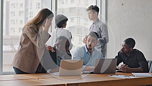 Multiracial group colleagues multi-ethnic co-workers corporate workers in office talking caucasian woman secretary