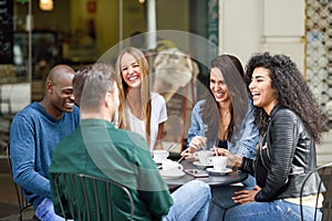 Multiracial group of five friends having a coffee together