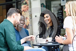 Multiracial group of four friends having a coffee together