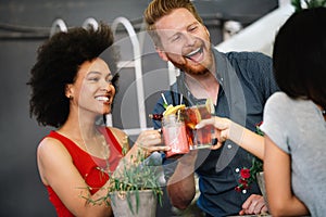 Multiracial group of friends having fun and talking in restaurant