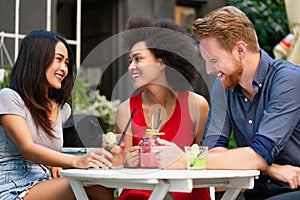 Multiracial group of friends having fun and talking in restaurant