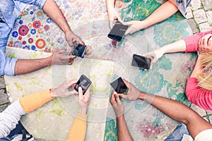 Multiracial group of friends mobile addicted - Wifi connected people in bar table meeting - Top view hands circle using mobile