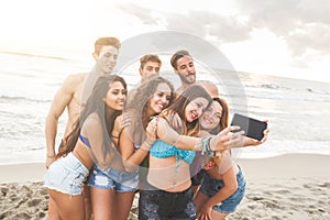 Multiracial group of friends taking selfie on the beach