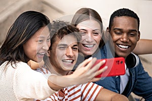 Multiracial group of friends taking a selfie outside.Young beautiful people taking a picture smiling and sitting in