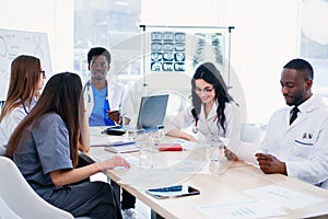 Multiracial group of professional medical doctors have a meeting at conference room in hospital. The team of young