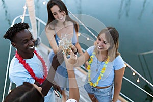 Multiracial group of young friends celebrating new year christmas on a boat