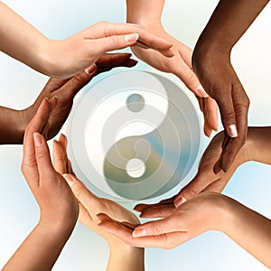 Multiracial Hands Surrounding Yin Yang symbol photo