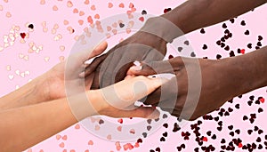 Multiracial handshake between black African man and white Caucasian woman. Two people holding hands in respect and solidarity