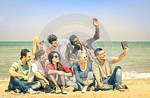 Multiracial happy friends taking selfie with tablet at beach