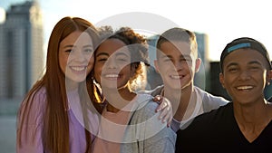 Multiracial high school pupils smiling camera, hugging friends togetherness