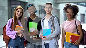 Multiracial high school students with books smiling camera, educational program