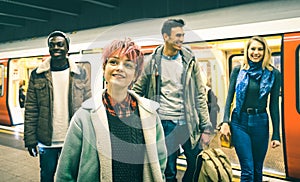 Multiracial hipster friends group walking at tube subway station