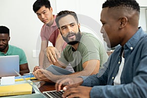 Multiracial male coworkers brainstorming ideas and strategies for achieving business goals